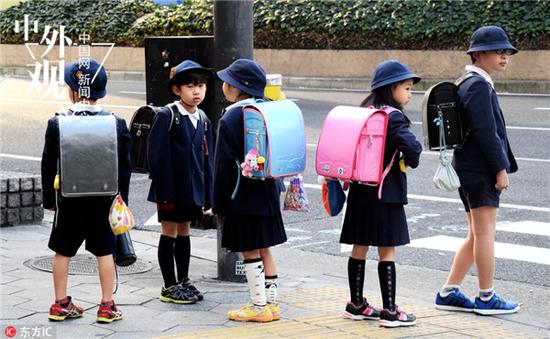 2016年3月1日，大阪，小学生穿着短裙或短裤，上身只穿着单薄的衬衣和校服，一身夏天的打扮去上学。（东方IC）