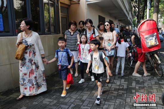 资料图:家长护送孩子们上学。殷立勤 摄