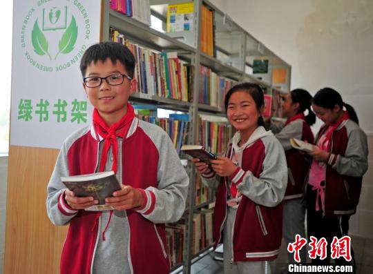 资料图:小学生在“绿书”书架上挑选自己喜爱的课外书 史伟 摄