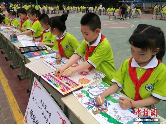 资料图:小朋友展示书法、绘画作品,庆祝儿童节。 达媛 摄